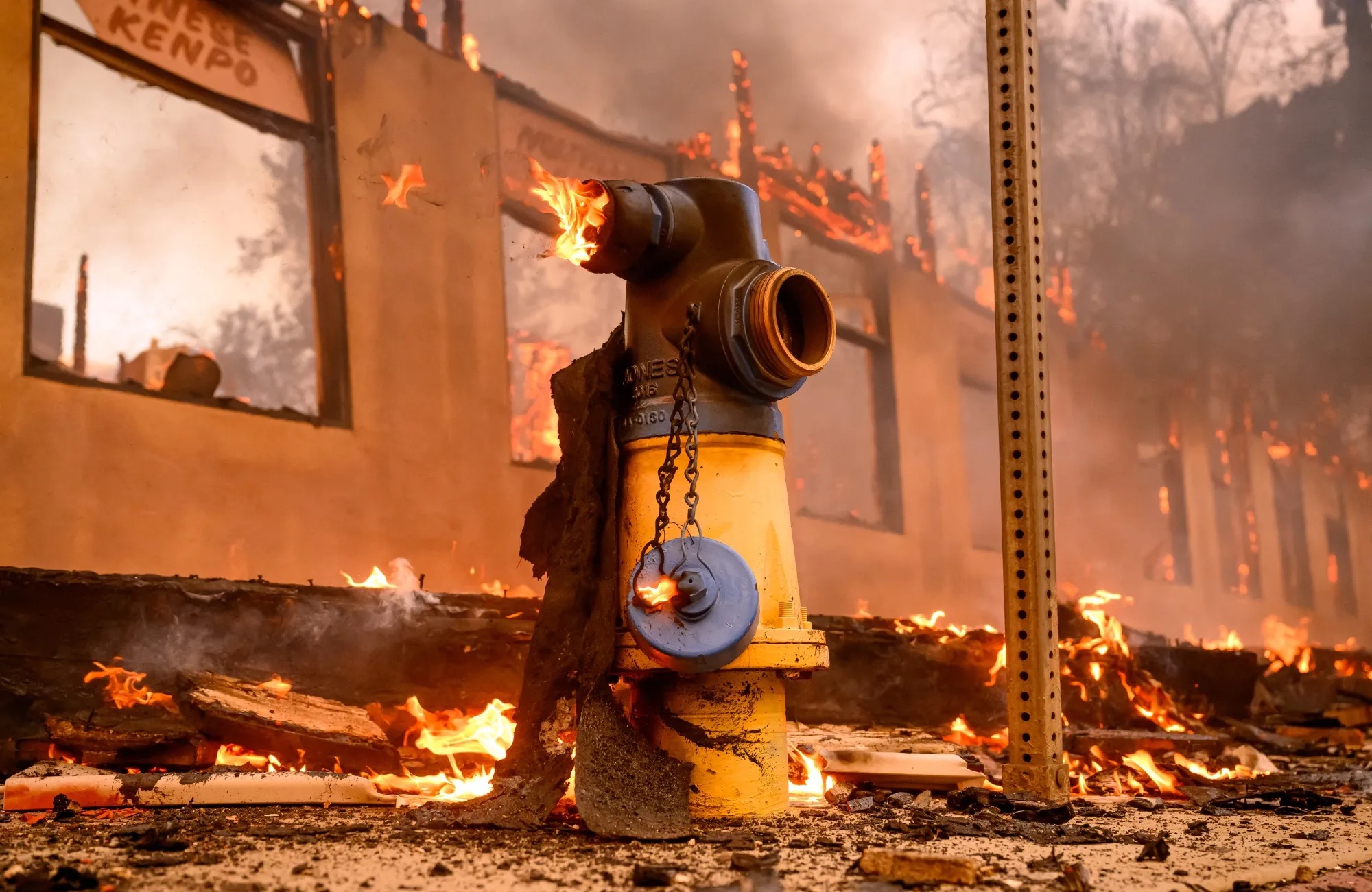 Fire hydrant with burning building in background