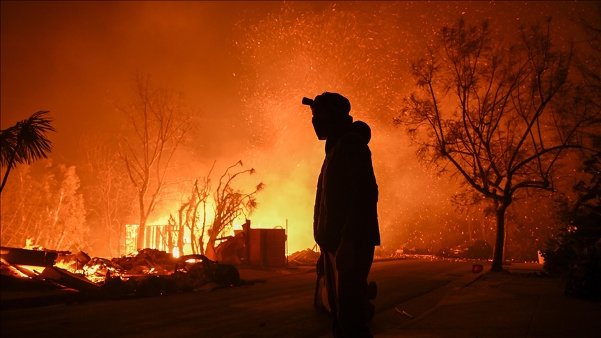 Silhouette of a person against wildfire background